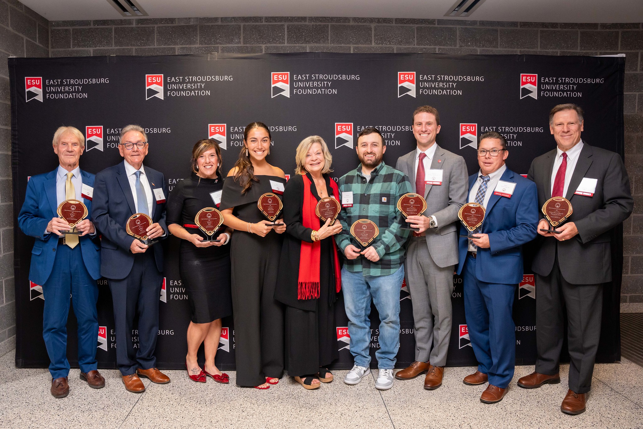 Recipients of the 2024 Alumni Awards. Each honoree is holding their award and grouped together.