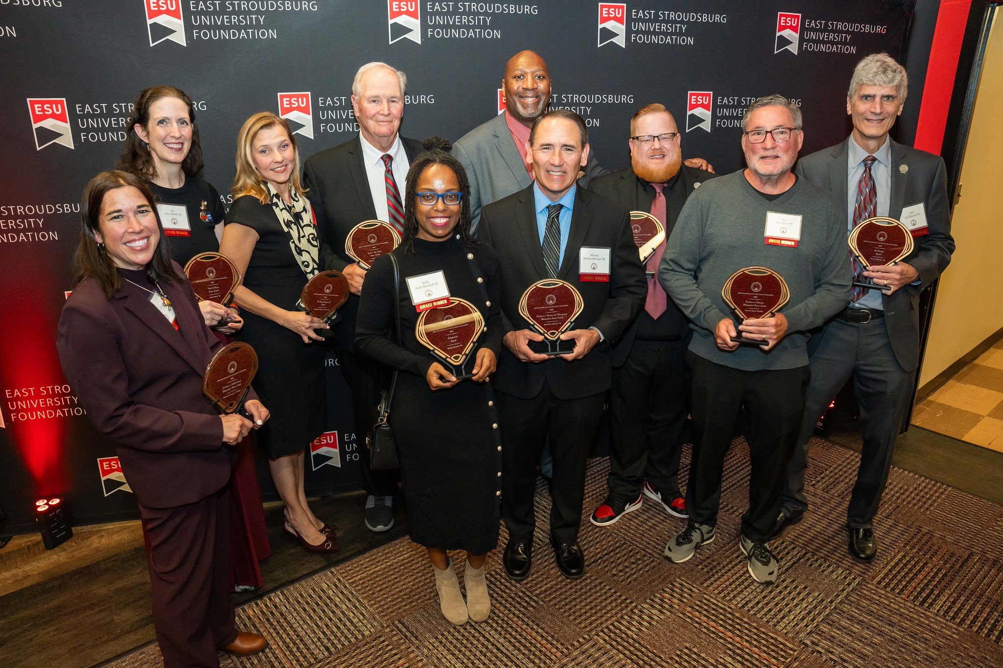 Recipients of the 2024 Alumni Awards. Each honoree is holding their award and grouped together.